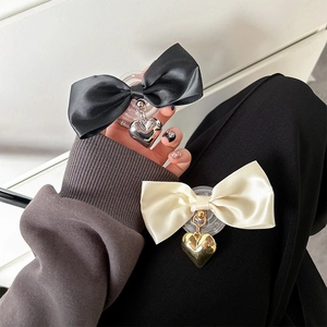Elegant satin bow phone grip with metallic heart pendant in black and cream white