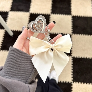 Detail of rhinestone heart phone socket with a large cream bow held in hand