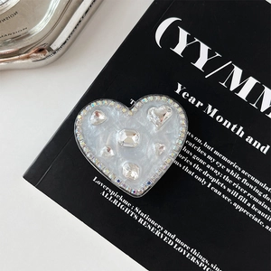 Macro shot of heart-shaped phone grip with glitter and sparkling rhinestones