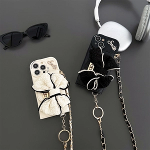 Detail of luxury bowknot phone case with Smile diamond lettering and crossbody metal chain