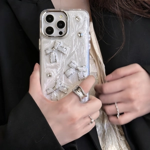 Detail of silver glitter phone case with metallic bows and rhinestones for iPhone