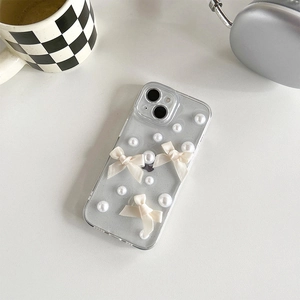 Détail de la coque iPhone pailletée ornée de nœuds en satin et de perles élégantes