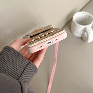 Pink tweed phone case for iPhone 16 Pro Max with crossbody strap and rhinestone details