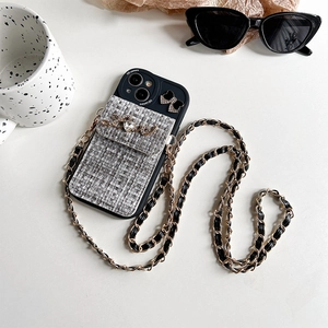 Detail of luxury tweed wallet phone case with gold Love hardware and crossbody chain strap