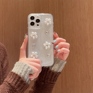 Dettaglio custodia iPhone con fiori di perle 3D e strass su retro trasparente glitterato