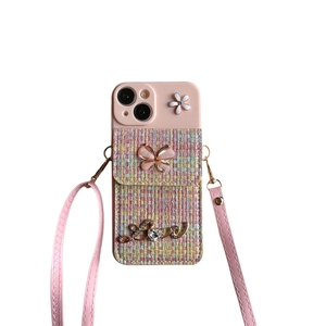 Pink iPhone crossbody case with woven pattern, butterfly charm, and adjustable strap