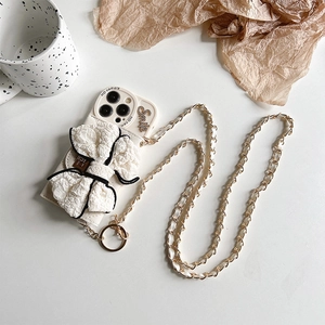 Detail of cream bow phone case with crossbody metal chain strap and Smile ornament