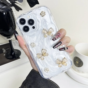 Detail showing 3D gold butterfly and white floral embossed charms on iPhone pearl texture case