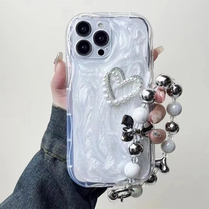 Detail of iPhone case with white marble pattern, pearl heart, and beaded wrist strap