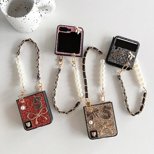 Detail of glitter folding phone cases with pearl chains, bowknots and number 5 charms