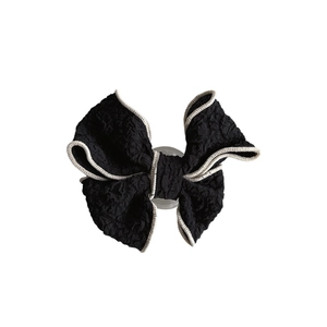 Elegant black fabric bow phone socket grip with white trim and retractable design