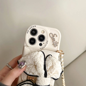 Detail of cream bow phone case with rhinestone Smile text and golden crossbody chain
