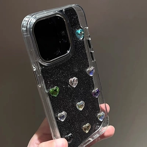 Macro detail of heart-shaped colorful gemstones on black glitter iPhone case surface