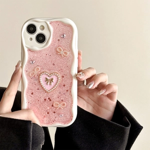 Nahaufnahme der rosa Glitzer iPhone Hülle mit Perlenbogen und Herzdeko in den Händen