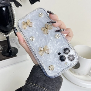 Macro detail of iPhone case with 3D gold-edged butterfly and rose flower embellishments