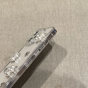 Dettaglio ravvicinato della custodia iPhone con perle bianche, cristalli e glitter argento