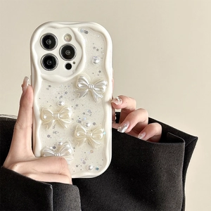 Detail of cream wavy phone case with 3D pearl bow and glitter stars for iPhone