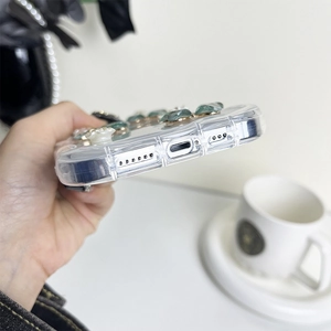 Detail of clear iPhone case with green gemstones and precise bottom speaker cutouts