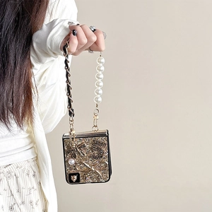 Detail of luxury glitter phone case with pearl chain handle and bow relief decoration
