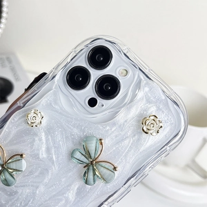 Detail of iPhone case with 3D white flowers, blue butterflies and mother of pearl back