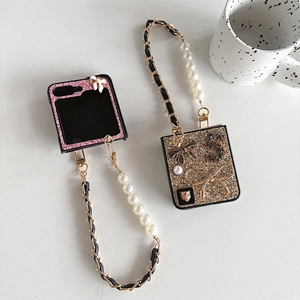 Close-up of pink and gold glitter folding phone cases with pearl chains and bow charms