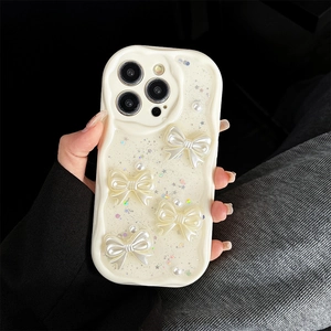 Close-up of cream iPhone case with pearl bows, sparkling sequins and wave edges