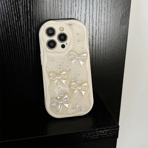 Detail view of cream wavy phone case with 3D pearl bows and sparkling sequins