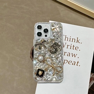 Detail of luxury glitter phone case featuring sparkling crystals and pearl bow accents