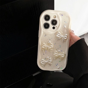 Detail of cream white wave-edge iPhone case with 3D pearl bows and glitter stars
