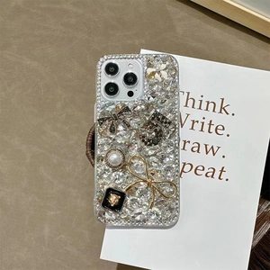 Detail of luxury iPhone case with crystals, pearls, bowknot and lion head embellishment