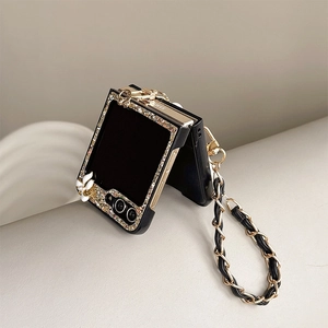 Close-up of glitter sequins, 3D white flowers and leather metal chain on black phone case
