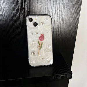 Détails d'une coque iPhone avec tulipes, perles et cristaux en forme de cœur sur socle