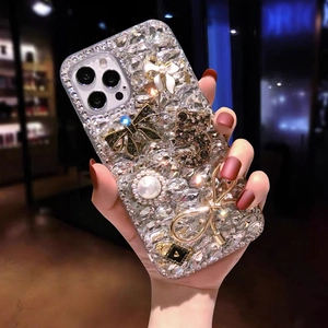 Detail of luxury iPhone case featuring rhinestone bow, pearls and gold number 5 decoration