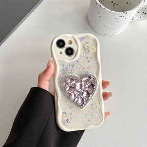 Close-up of wavy cream phone case with rhinestone heart and pearl bow for iPhone
