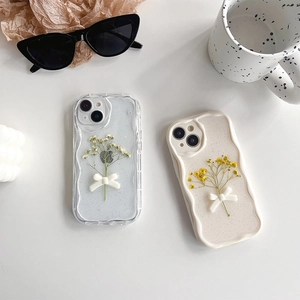 Detail of floral iPhone cases with 3D bows and glitter on a wave-edge transparent cover