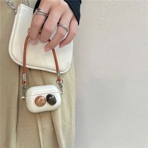 Stylish cream AirPods Pro case with handle strap and decorative gemstone accents