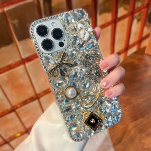 Luxury iPhone case detail featuring sparkling rhinestones, black bow, and pearl charms