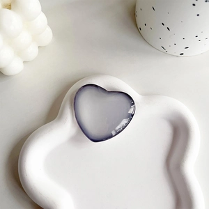 Detail of gradient purple heart-shaped crystal phone socket on a white petal tray