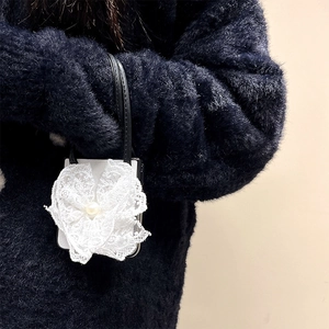 Leather folding phone case with white lace flower and pearl detail on a hand strap