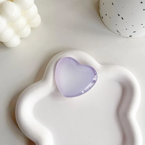 Close-up of heart-shaped gradient crystal phone grip on white decorative cloud tray