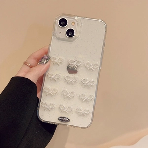 Detailed macro of iPhone case with silver glitter and twelve white pearl 3D bows