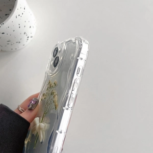 Detail view of transparent iPhone case with dried flowers, bow, and wavy edge design