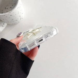 Detail shot of precise charging port and speaker cutouts on clear glitter flower phone case