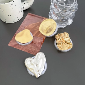 Close-up of assorted metallic pleated and heart-shaped magnetic phone sockets on grey desk