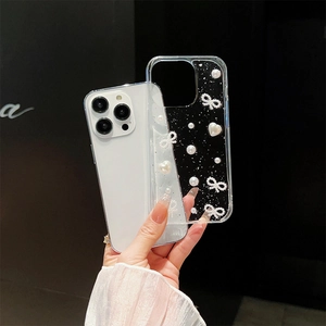 Clear iPhone case with white pearls, glitter, and a woven bow on a black background