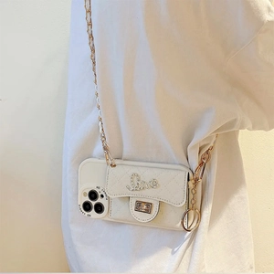 Detailed view of white quilted phone case with rhinestone Love buckle and crossbody chain
