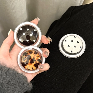Detail of round phone sockets with leopard print and heart patterns on textured fabric
