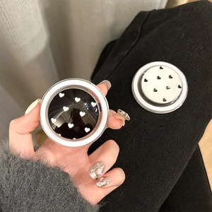 Detail of magnetic crystal ball phone grips with heart patterns in black and white styles