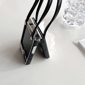 Detail of luxury black leather foldable phone case with crossbody strap and lace accent