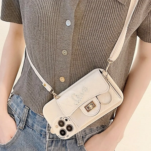 Detail of cream quilted phone wallet case with diamond Love buckle and metal chain strap